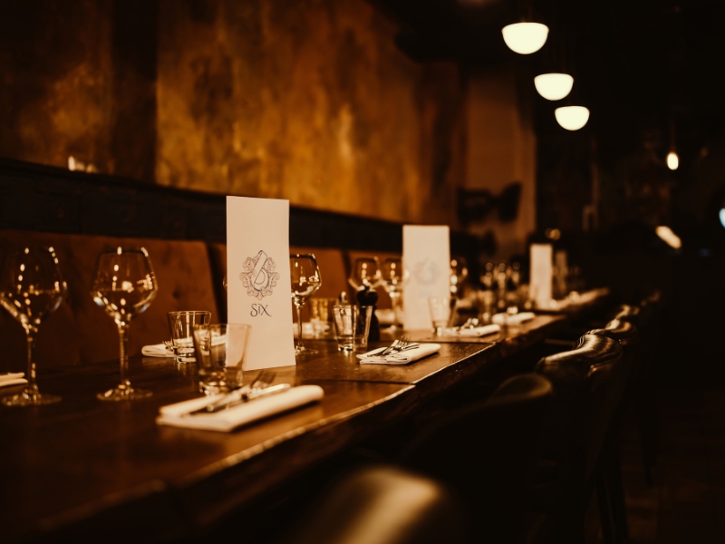 Salle restaurant Six banquette Un côté de la salle du restaurant avec banquettes et tables dressées.